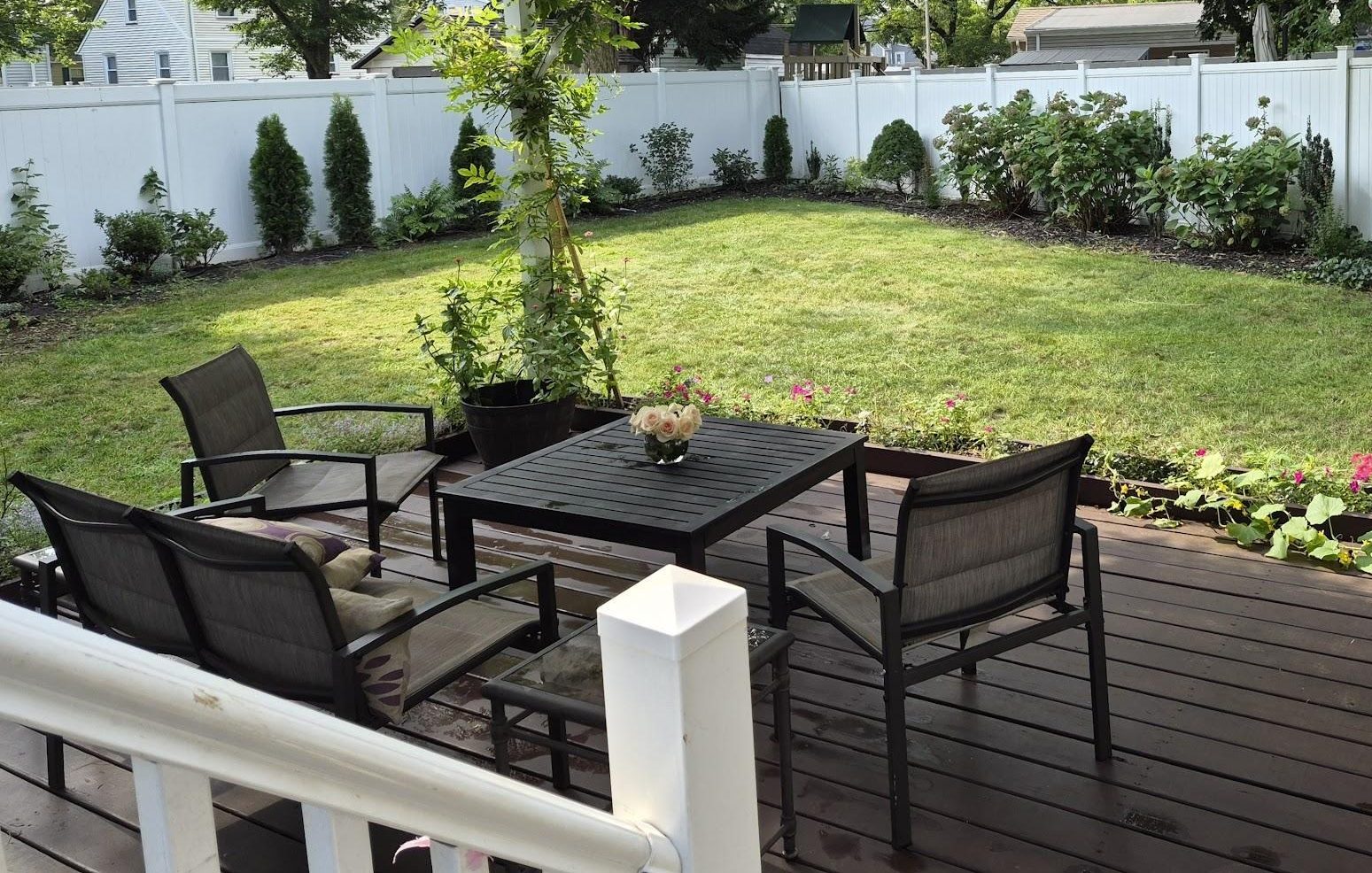 Backyard deck and garden after the old pergola was removed, showing the open space available for a new shade structure.